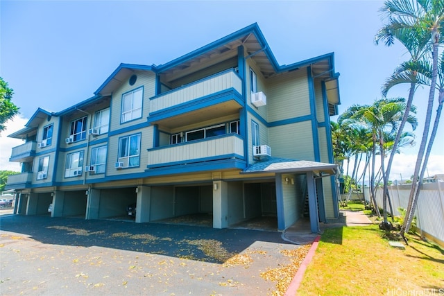 view of front facade with a carport and a balcony