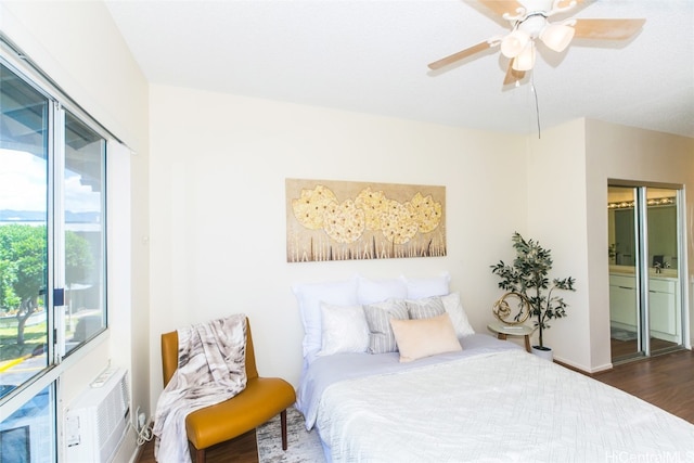 bedroom featuring dark hardwood / wood-style floors, a wall mounted AC, and ceiling fan