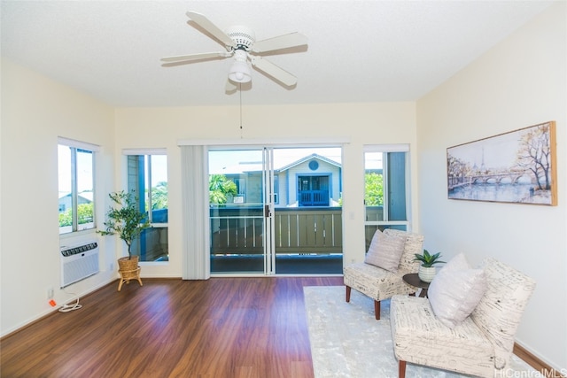 sitting room featuring hardwood / wood-style floors, cooling unit, ceiling fan, and plenty of natural light