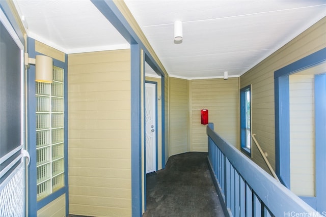 hallway featuring wooden walls