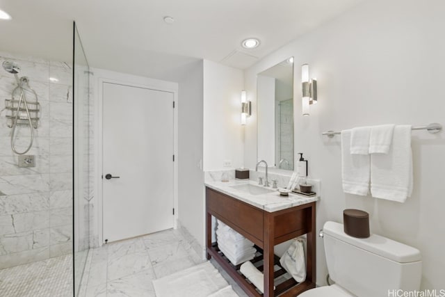 bathroom with toilet, vanity, and a tile shower