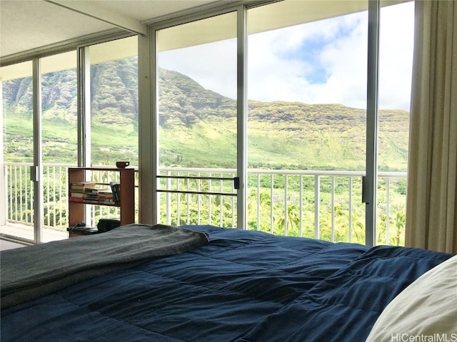 bedroom featuring access to outside and a wall of windows