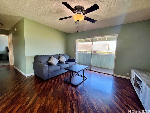 living room with ceiling fan, a textured ceiling, and dark hardwood / wood-style floors