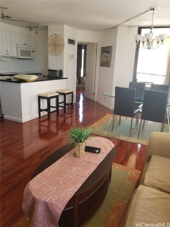 living room with an inviting chandelier and dark hardwood / wood-style floors