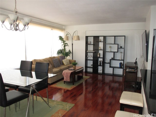 living room with a notable chandelier and dark wood-type flooring