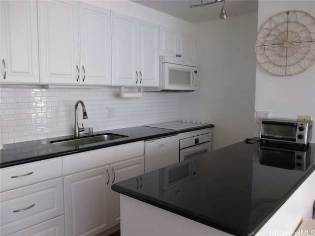 kitchen featuring sink, white cabinetry, decorative backsplash, and white appliances