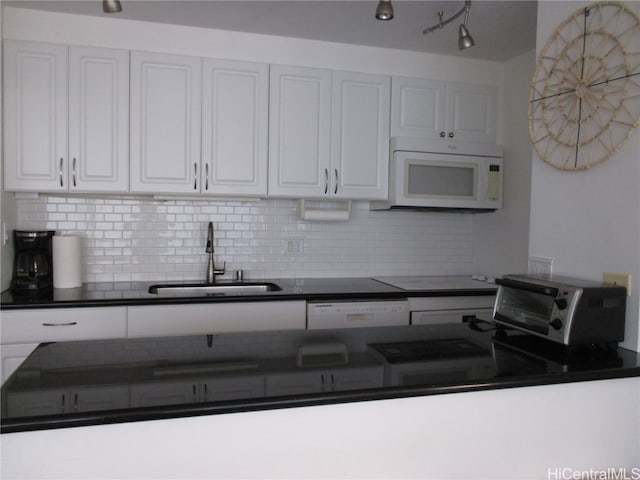 kitchen featuring sink, white cabinets, decorative backsplash, and white appliances