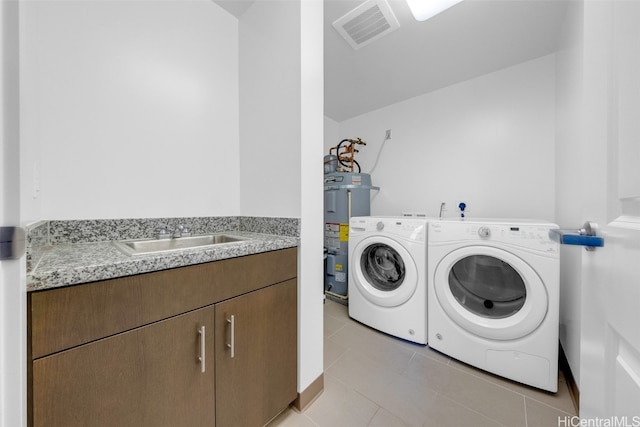 washroom with strapped water heater, sink, washing machine and clothes dryer, and light tile patterned floors