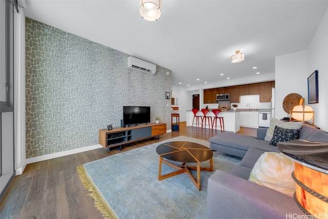 living room featuring a wall mounted AC, sink, and dark hardwood / wood-style flooring