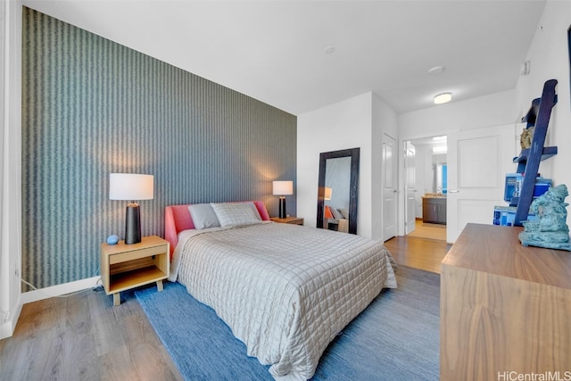 bedroom with hardwood / wood-style flooring and ensuite bath