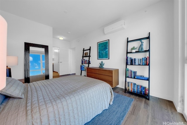 bedroom featuring a wall mounted AC and hardwood / wood-style flooring