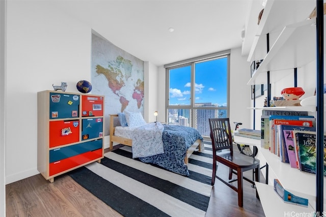 bedroom featuring a wall of windows and wood-type flooring