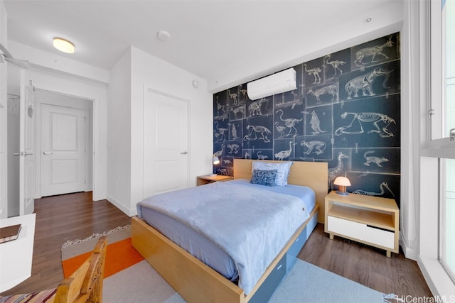 bedroom with a wall mounted air conditioner and dark hardwood / wood-style floors