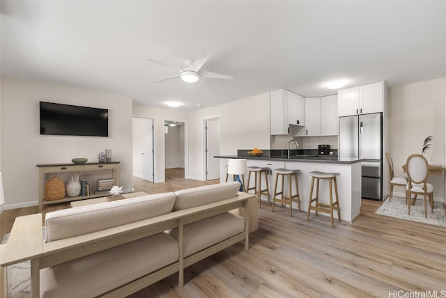 living room with ceiling fan and light wood-type flooring