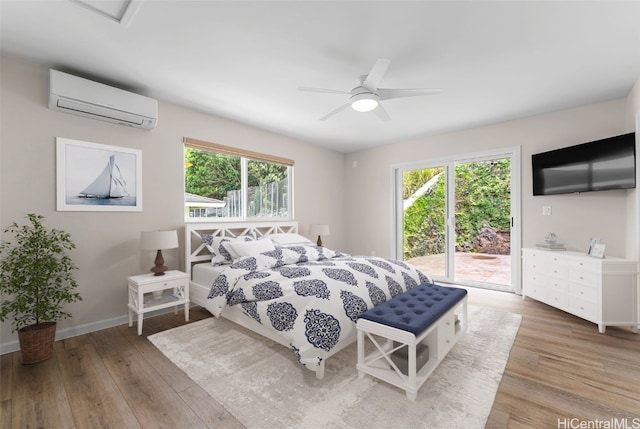 bedroom featuring hardwood / wood-style flooring, ceiling fan, a wall mounted air conditioner, and access to outside