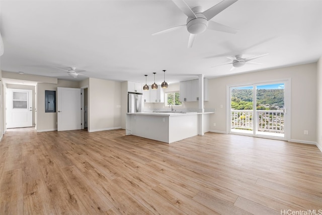 unfurnished living room featuring ceiling fan, sink, and light hardwood / wood-style floors