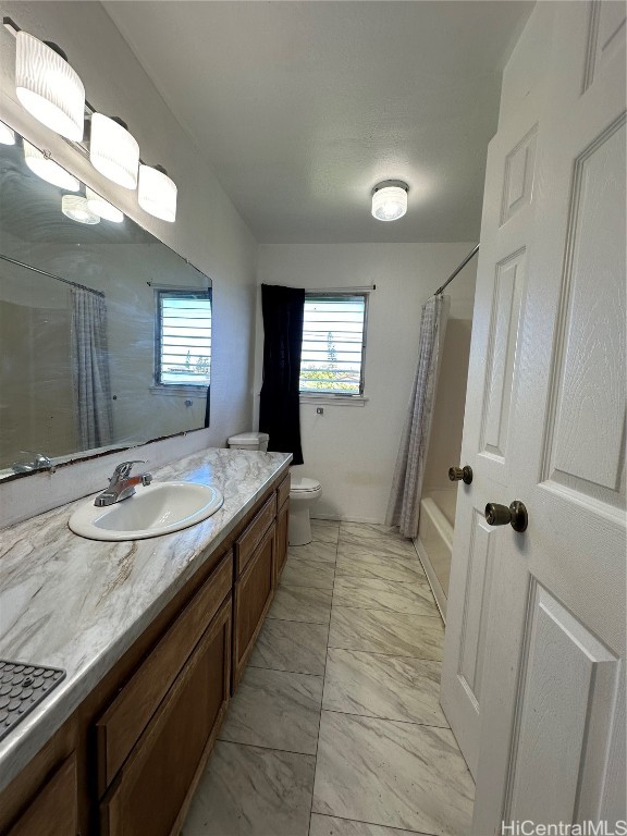 full bathroom with toilet, shower / bath combo with shower curtain, and vanity