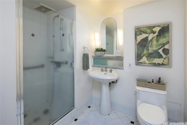 bathroom featuring toilet, a shower with shower door, and tile patterned floors