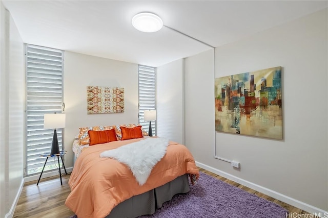 bedroom with multiple windows and light hardwood / wood-style flooring