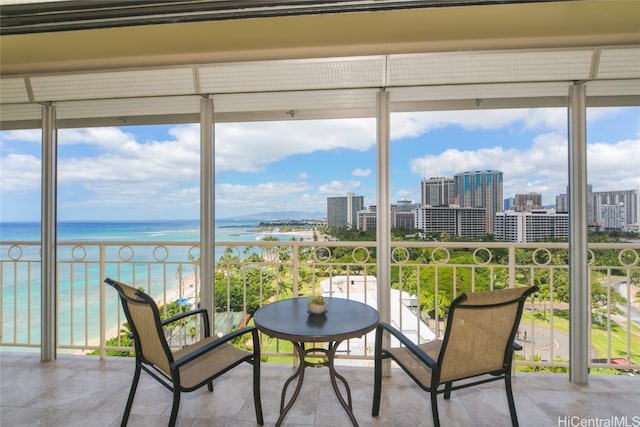 sunroom / solarium with a wealth of natural light, a water view, and a view of the beach