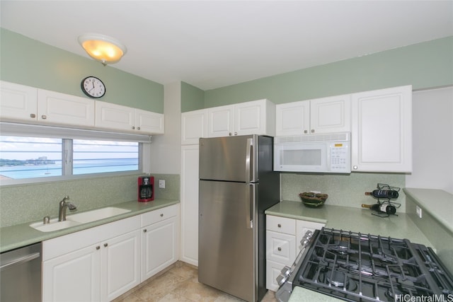 kitchen featuring sink, white cabinets, decorative backsplash, and stainless steel appliances