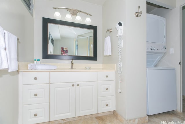 bathroom with vanity, stacked washer / drying machine, and a shower