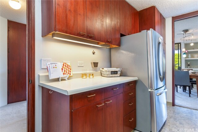 kitchen featuring stainless steel refrigerator and a textured ceiling