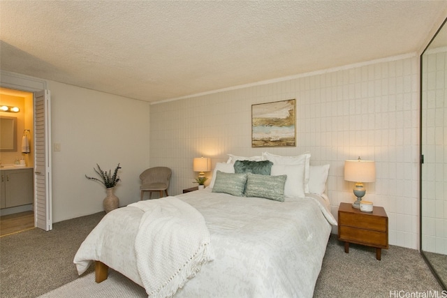 bedroom featuring tile walls, connected bathroom, carpet, and a textured ceiling