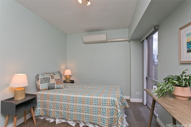 bedroom with dark hardwood / wood-style floors and a wall unit AC