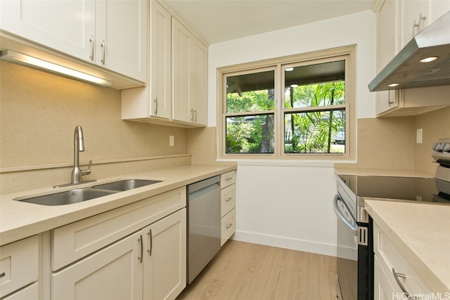 kitchen with sink, white cabinetry, stainless steel appliances, and light wood-type flooring