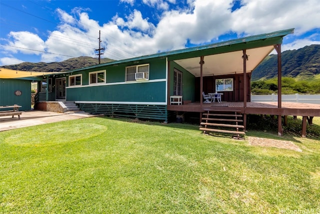 rear view of property featuring a patio area, a mountain view, and a yard