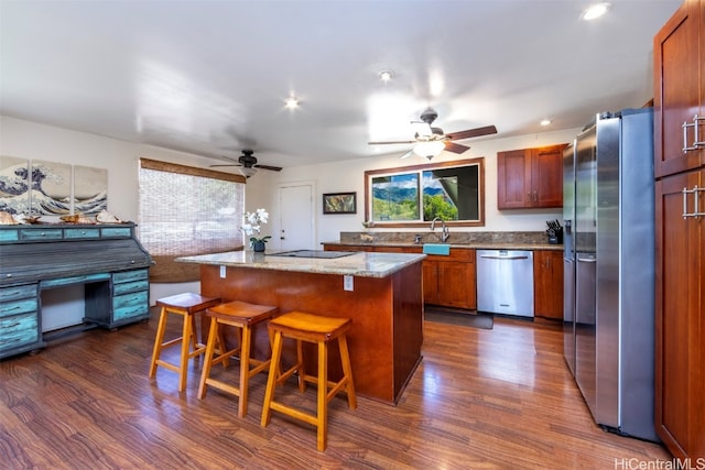 kitchen featuring dark hardwood / wood-style flooring, a wealth of natural light, a center island, and stainless steel appliances