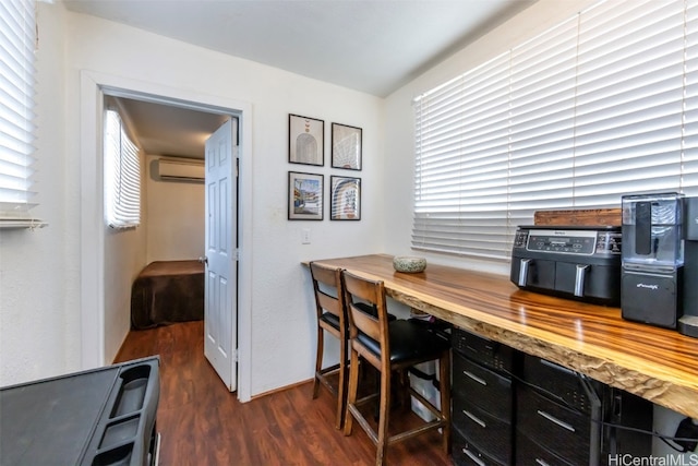 office with a wall unit AC and dark hardwood / wood-style floors