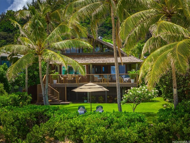 rear view of property with a deck and a yard