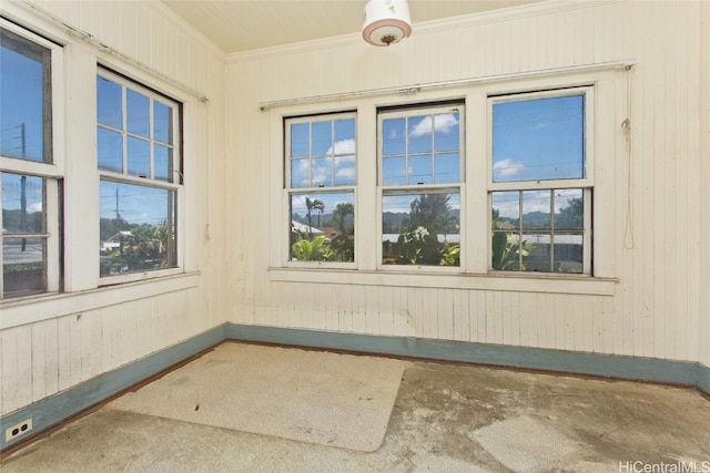 spare room with crown molding, carpet flooring, and wood walls