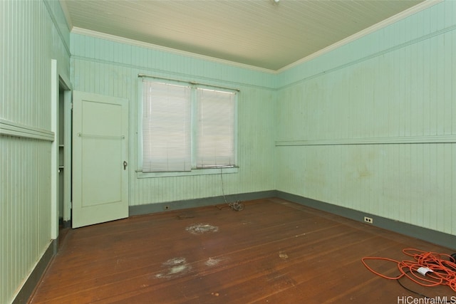 unfurnished room with wood walls, ornamental molding, and dark hardwood / wood-style flooring