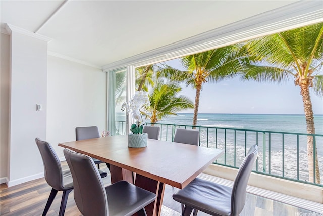 2999 Kalakaua Ave Unit 202, Honolulu, HI 96815 - dining space featuring baseboards, crown molding, wood finished floors, and a water view