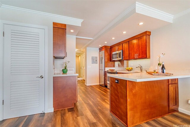 2999 Kalakaua Ave Unit 202, Honolulu, HI 96815 - kitchen featuring crown molding, a sink, light countertops, a peninsula, and appliances with stainless steel finishes