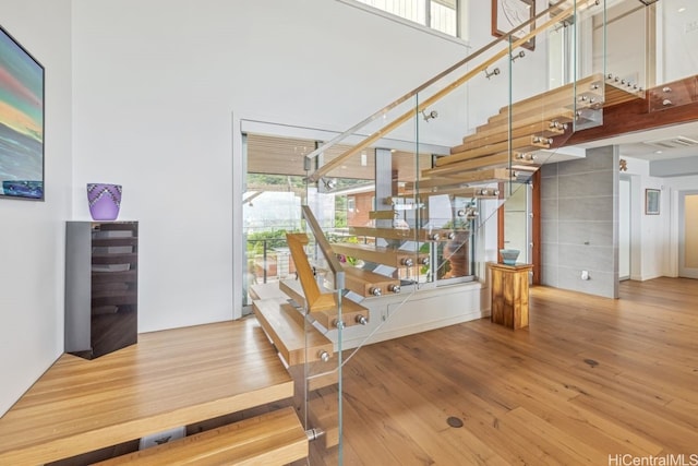 stairs with a high ceiling and hardwood / wood-style flooring