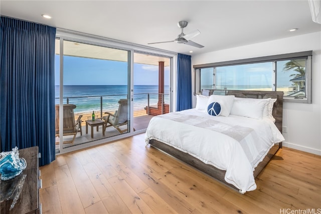 bedroom featuring access to exterior, ceiling fan, a water view, and light wood-type flooring