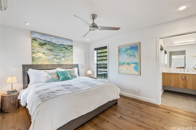 bedroom featuring light hardwood / wood-style floors, ensuite bath, and ceiling fan