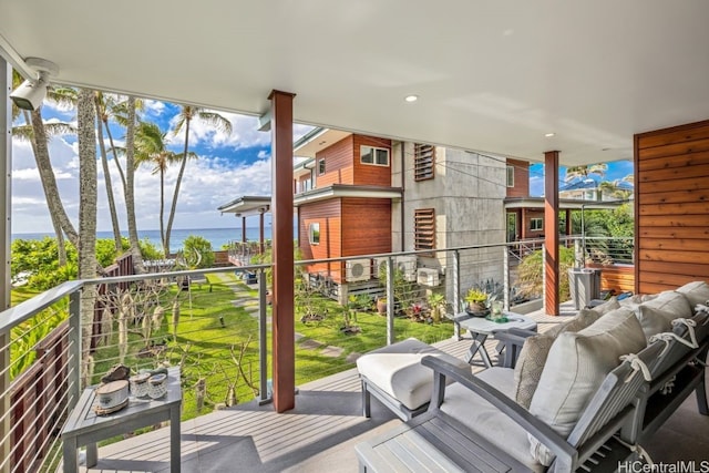 balcony with a water view and an outdoor hangout area