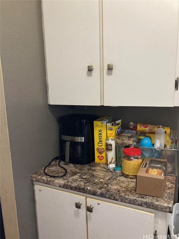 room details featuring white cabinets and dark stone countertops