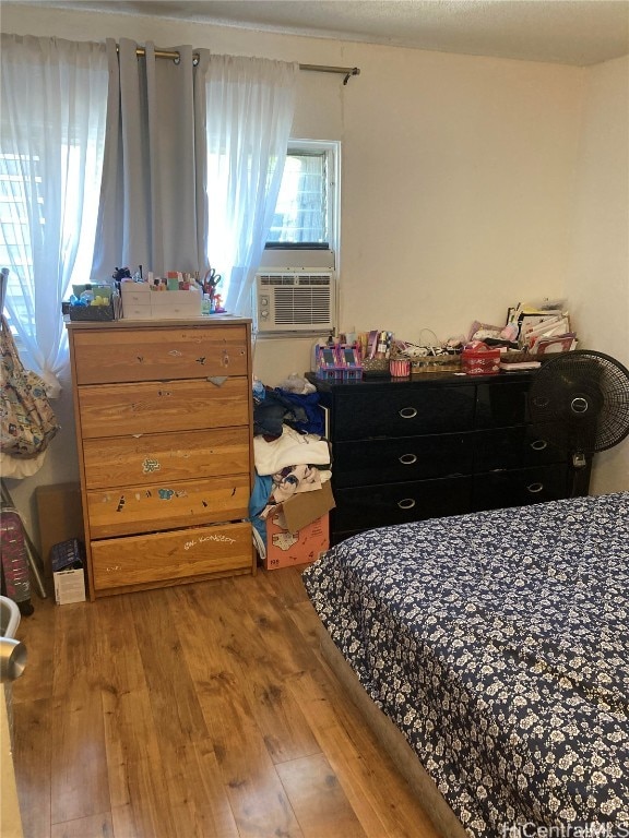 bedroom with cooling unit and hardwood / wood-style floors