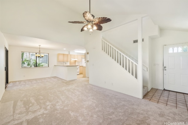 unfurnished living room with light tile patterned flooring, ceiling fan with notable chandelier, and high vaulted ceiling