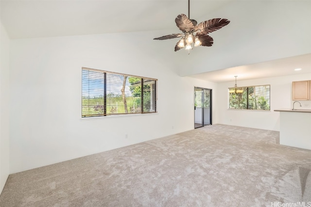 empty room featuring sink, vaulted ceiling, light carpet, and ceiling fan