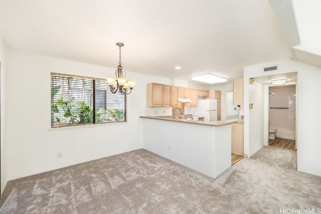 kitchen with white fridge, kitchen peninsula, light carpet, and light brown cabinets