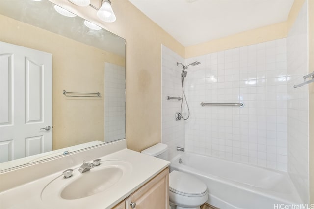 full bathroom with tiled shower / bath, vanity, and toilet