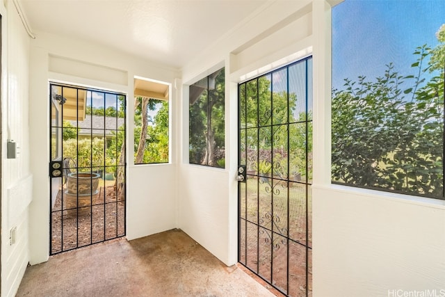 entryway with carpet flooring, a wealth of natural light, and ornamental molding