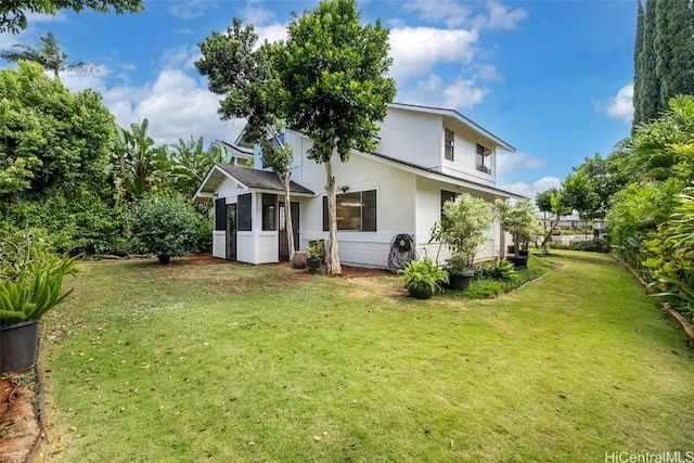 rear view of property featuring a lawn